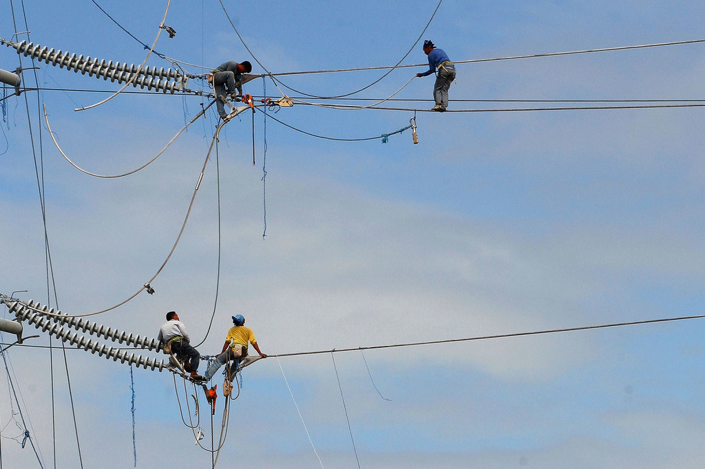 کارگران کابل های برق را در لوزون جنوبی فیلیپین نصب می کنند.